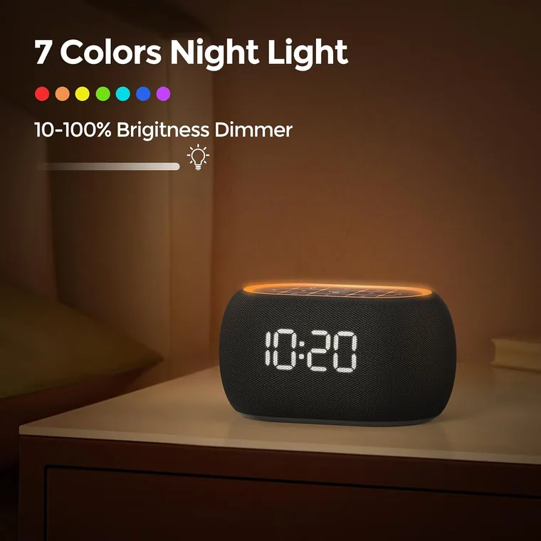 A compact sound machine glowing on a nightstand in a dark bedroom